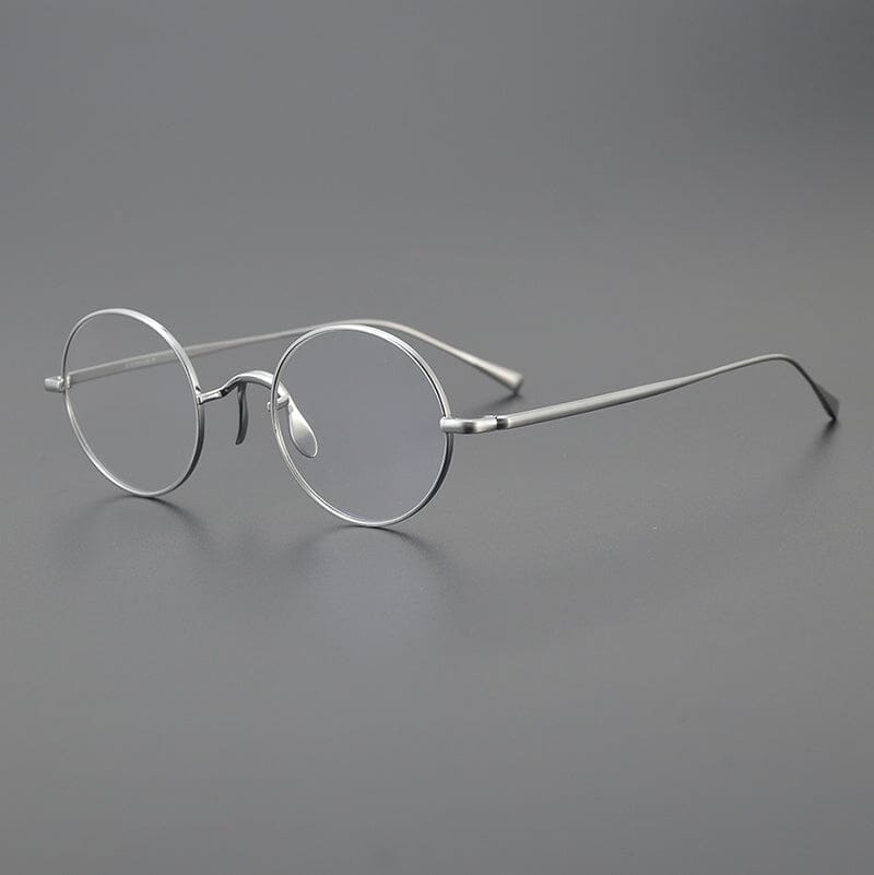 Monturas de gafas redondas de titanio con aros de alambre fino y varillas metálicas delgadas