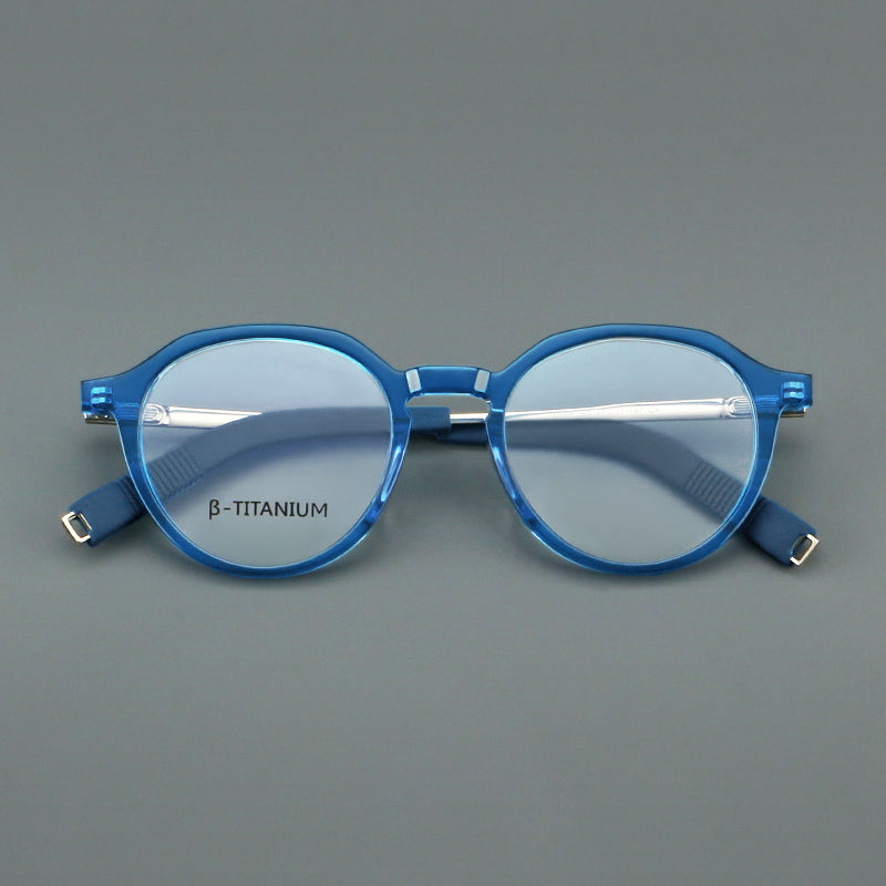 Monturas de gafas redondas de aleación de titanio con borde superior esculpido y puente metálico