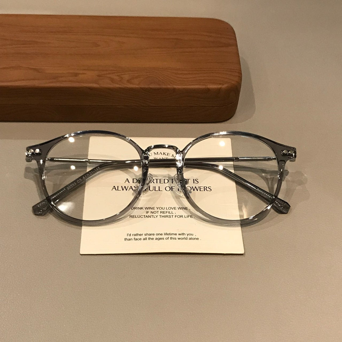 Montura de gafas geométrica redondeada con bordes translúcidos, gris hielo