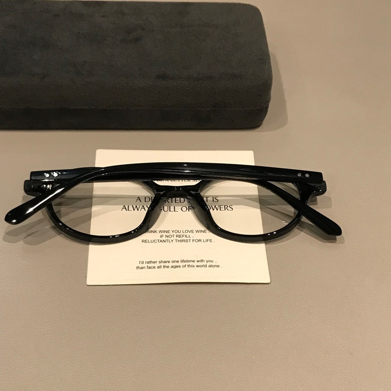 Montura de gafas redondas retro con bordes gruesos y puente elevado, negro