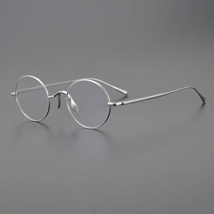 
Monturas de gafas redondas de titanio con aros de alambre fino y varillas metálicas delgadas