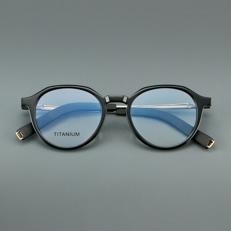 
Monturas de gafas redondas de aleación de titanio con borde superior esculpido y puente metálico