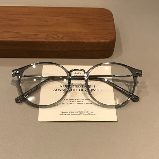 Montura de gafas geométrica redondeada con bordes translúcidos, gris hielo